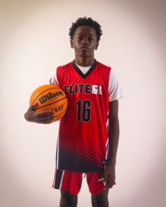 A boy in a red basketball jersey, 16