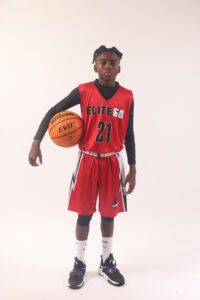 A boy in a red basketball jersey, 27