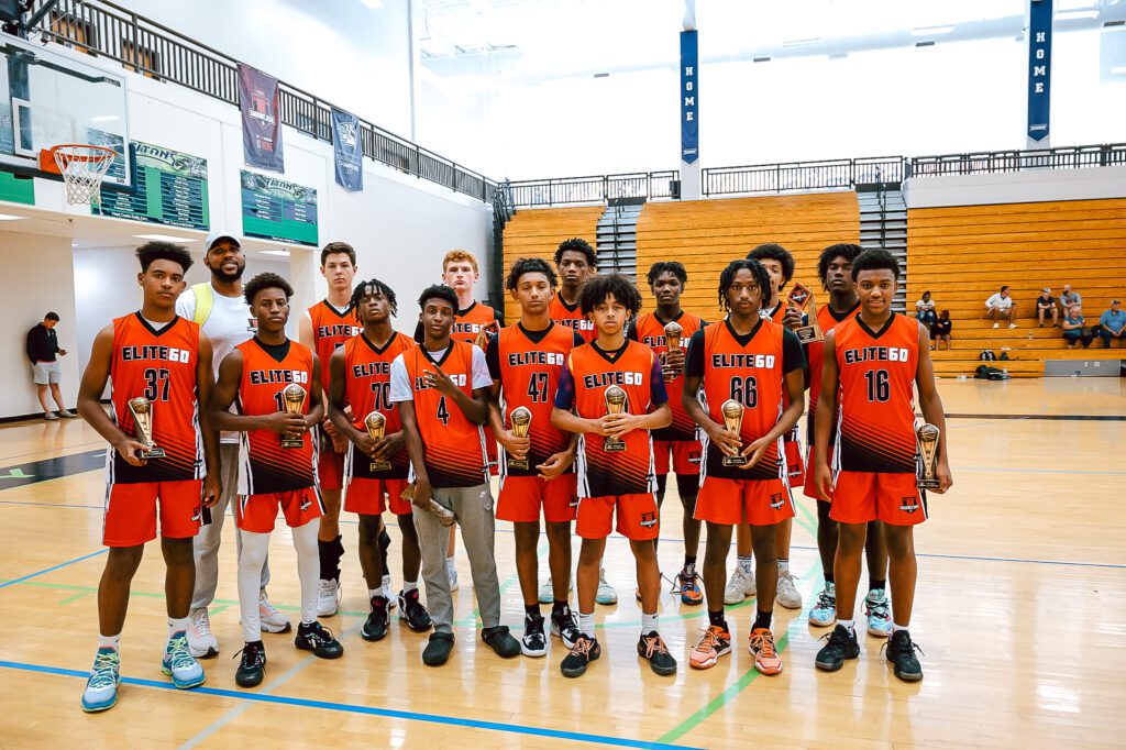 The Elite60 basketball team (red jersey) holding trophies