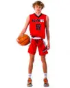 A blond boy in a red basketball jersey holding a ball on his side