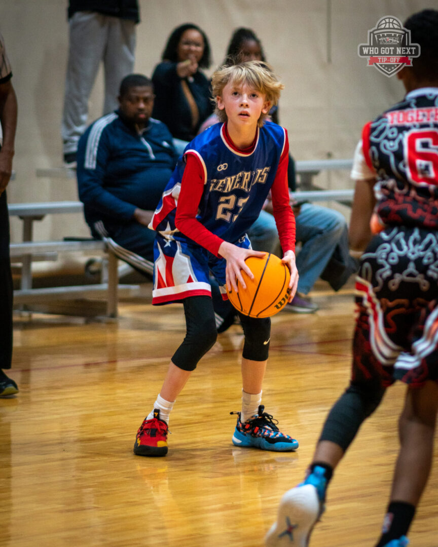 A girl in blue and red color jersey holding abasket ball