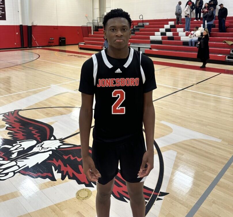 Young basketball player standing on a gym court, wearing black jersey number 2.