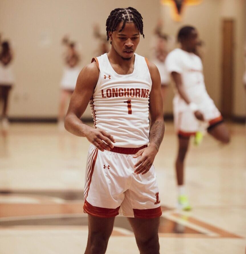 Basketball player in white uniform preparing on court.