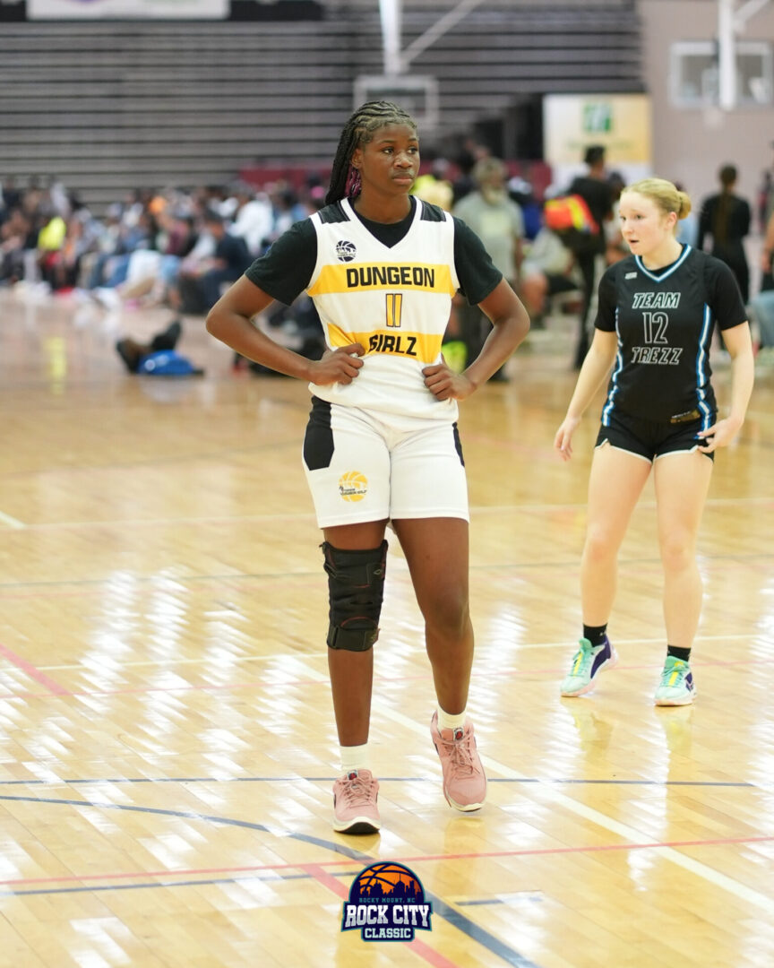 High school girls playing basketball in a gym.