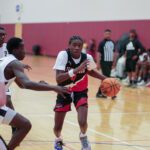 Young basketball player dribbling past a defender during a game.