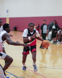 Young basketball player dribbling past a defender during a game.
