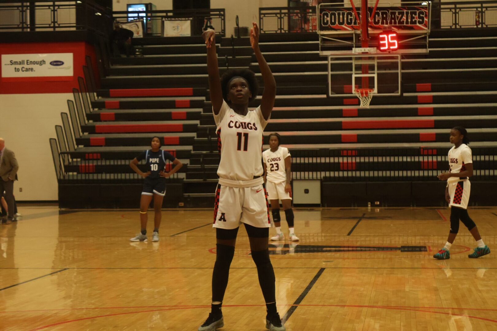 Basketball player taking a free throw shot in a gym.
