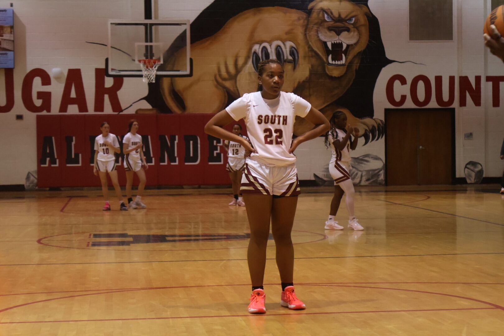 Youth basketball player in a white uniform on court.