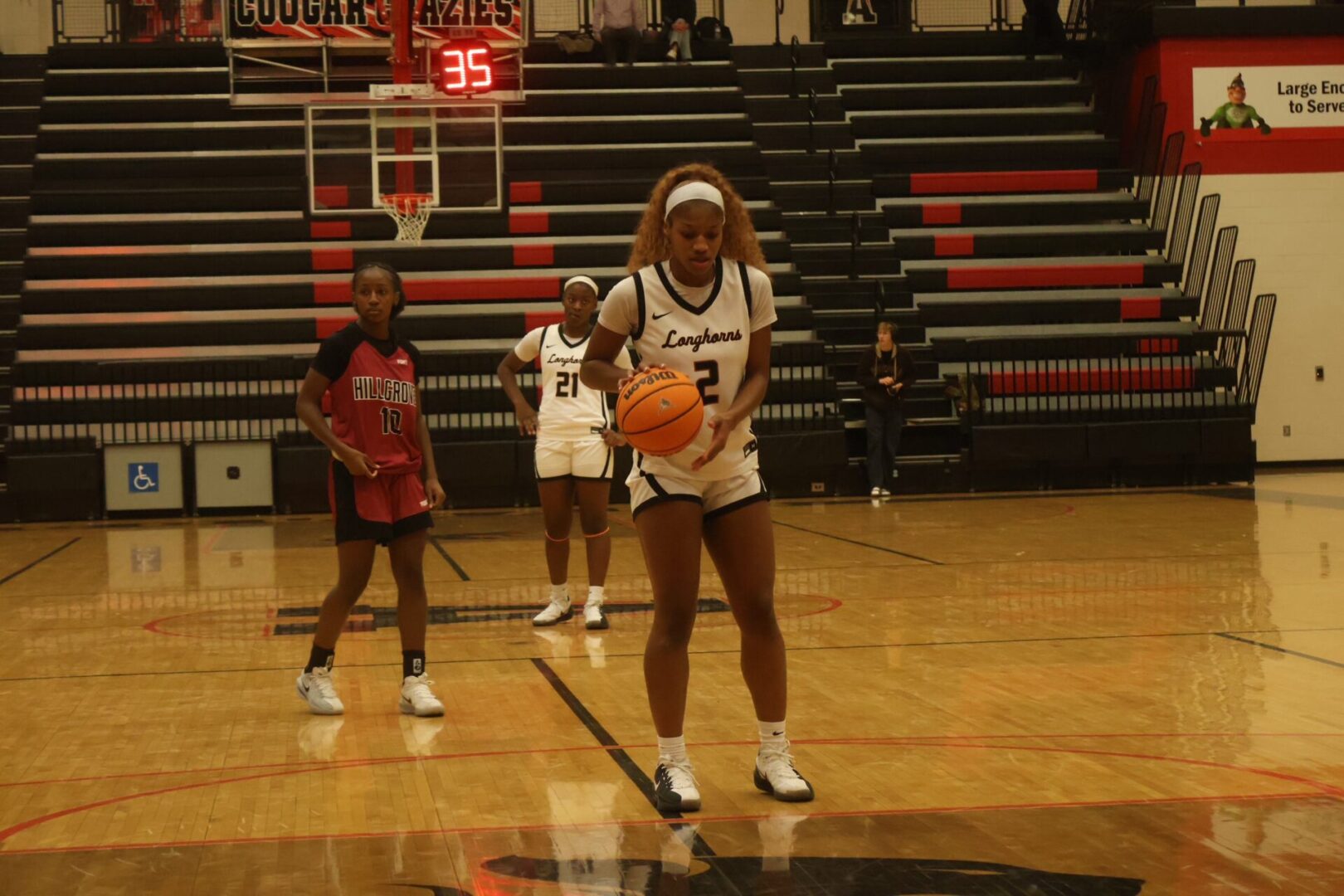 Female basketball player preparing to shoot a free throw in a gym.