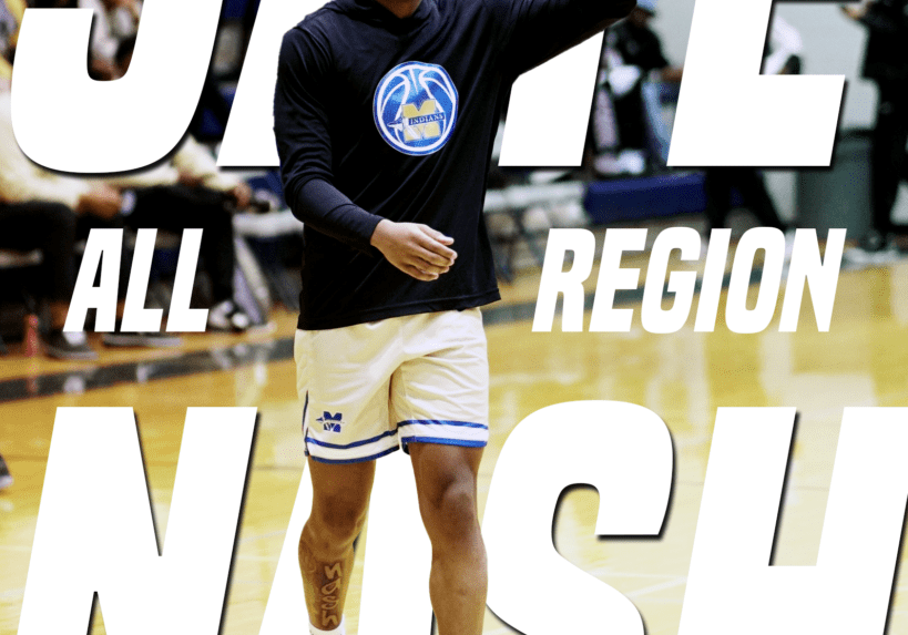 Basketball player warming up on court wearing black hoodie and shorts.