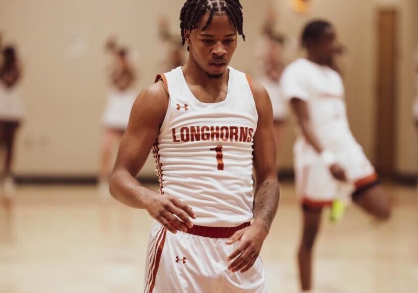 Basketball player in white uniform preparing on court.