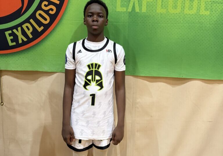Young basketball player posing in uniform on the court.