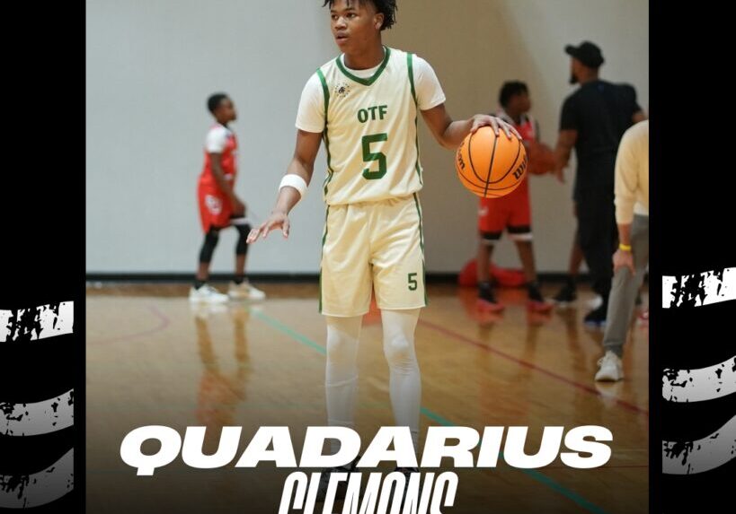Young basketball player wearing a white and green jersey with number 5 holding a basketball.