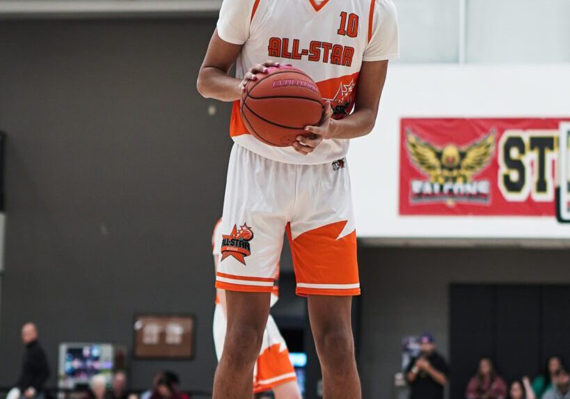 Basketball player in white uniform preparing to shoot during a game.
