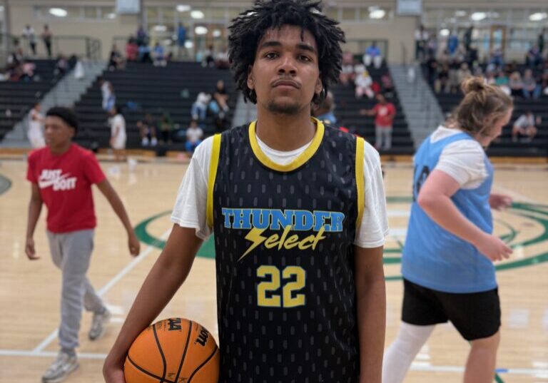 Young basketball player holding a ball on an indoor court.