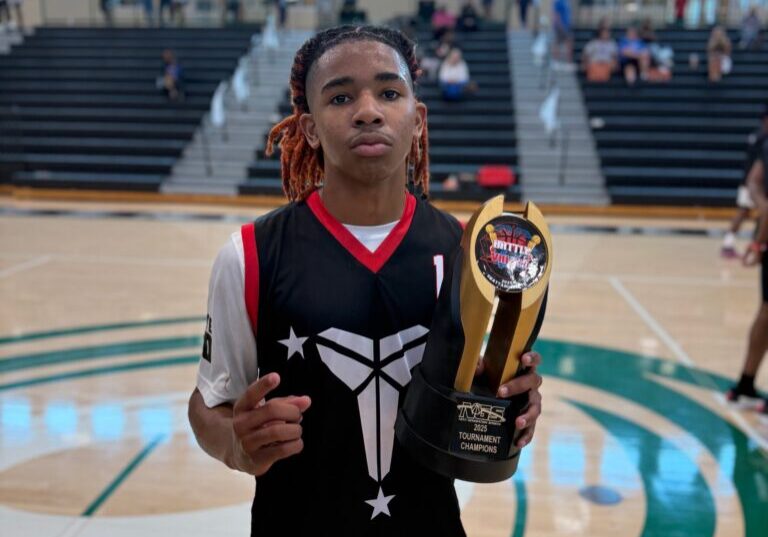 Young basketball player holding a trophy on the court.